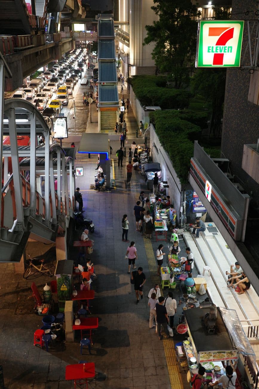 רחוב בבנגקוק בלילה עם סניף 7-Eleven, איפה קונים ומטעינים סים בתאילנד